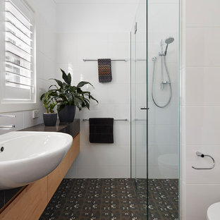Design ideas for a small contemporary 3/4 bathroom in Canberra - Queanbeyan with light wood cabinets, an alcove shower, a one-piece toilet, white tile, ceramic tile, white walls, cement tiles, a drop-in sink, marble benchtops, brown floor, a hinged shower door, black benchtops and flat-panel cabinets.