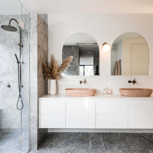 Contemporary master wet room bathroom in Geelong with raised-panel cabinets, white cabinets, white walls, a vessel sink, multi-coloured floor, a hinged shower door, white benchtops, a double vanity and a floating vanity.