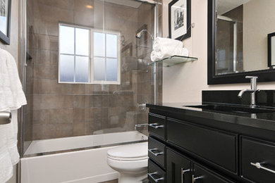 Example of a mid-sized trendy beige tile and porcelain tile porcelain tile bathroom design in San Francisco with an undermount sink, raised-panel cabinets, black cabinets, granite countertops, a one-piece toilet and beige walls