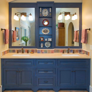 Ispirazione per una stanza da bagno padronale stile americano di medie dimensioni con ante a filo, ante blu, pareti beige, doccia alcova, piastrelle multicolore, piastrelle in gres porcellanato, pavimento in terracotta, lavabo sottopiano, top in superficie solida, pavimento beige e porta doccia a battente