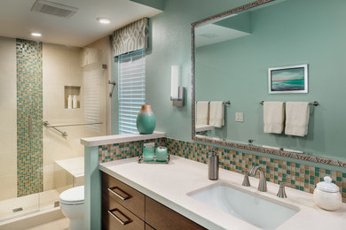 Example of a mid-sized beach style 3/4 multicolored tile and mosaic tile beige floor alcove shower design in San Diego with flat-panel cabinets, dark wood cabinets, blue walls, a hinged shower door, an undermount sink and white countertops