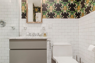 Example of a mid-sized trendy 3/4 white tile and subway tile alcove shower design in New York with flat-panel cabinets, beige cabinets, a one-piece toilet, multicolored walls and a hinged shower door