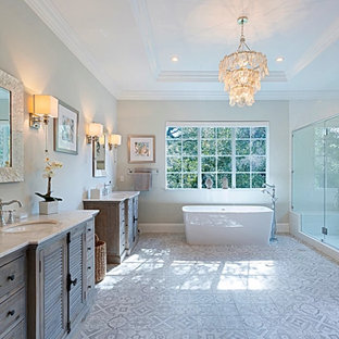 Example of a large beach style white tile ceramic tile, multicolored floor, double-sink and tray ceiling bathroom design in Miami with louvered cabinets, medium tone wood cabinets, gray walls, a drop-in sink, a hinged shower door and a freestanding vanity