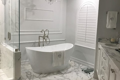 Example of a large transitional master gray tile, white tile and marble tile marble floor and gray floor bathroom design in Miami with recessed-panel cabinets, white cabinets, gray walls, an undermount sink, marble countertops, a hinged shower door and gray countertops