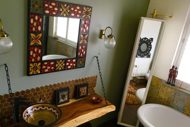 Large bohemian family bathroom in London with a freestanding bath, brown tiles, a vessel sink and wooden worktops.
