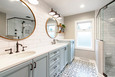 Example of a mid-sized trendy master white tile and subway tile porcelain tile, multicolored floor and double-sink bathroom design in Milwaukee with recessed-panel cabinets, blue cabinets, a two-piece toilet, beige walls, an undermount sink, quartz countertops, a hinged shower door, white countertops and a built-in vanity