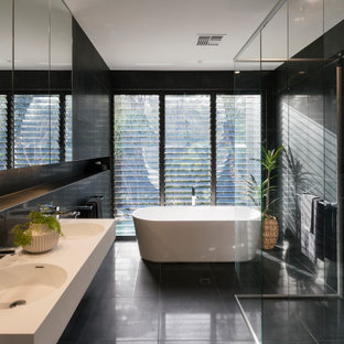 Inspiration for a contemporary master bathroom in Sunshine Coast with open cabinets, white cabinets, a freestanding tub, a curbless shower, black tile, an integrated sink, black floor, an open shower, white benchtops, a double vanity and a floating vanity.