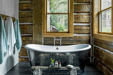 Example of a mountain style master gray floor freestanding bathtub design in Albuquerque with brown walls