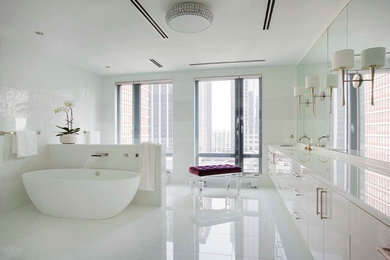 Foto de cuarto de baño principal actual con armarios con paneles lisos, puertas de armario blancas y bañera exenta