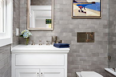 Alcove shower - small transitional kids' gray tile and mosaic tile mosaic tile floor alcove shower idea in Los Angeles with recessed-panel cabinets, white cabinets, an undermount tub, a wall-mount toilet, gray walls, an undermount sink and quartz countertops