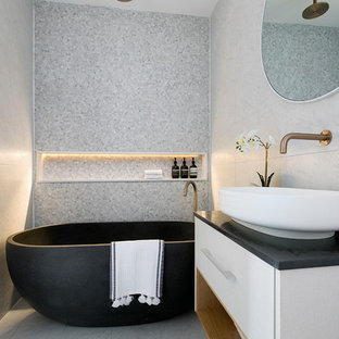 Inspiration for a contemporary bathroom in Sydney with flat-panel cabinets, white cabinets, a freestanding tub, an open shower, gray tile, ceramic tile, grey walls, ceramic floors, a vessel sink, engineered quartz benchtops, black benchtops, grey floor and an open shower.