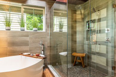Bild på ett mellanstort funkis grå grått en-suite badrum, med släta luckor, grå skåp, ett fristående badkar, en kantlös dusch, grå kakel, keramikplattor, ett nedsänkt handfat, bänkskiva i kvarts och dusch med gångjärnsdörr