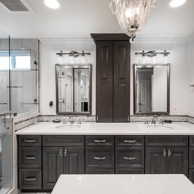 Corner shower - large traditional master black and white tile and marble tile porcelain tile and gray floor corner shower idea in Orange County with raised-panel cabinets, gray cabinets, a one-piece toilet, green walls, an undermount sink, a hinged shower door and quartz countertops