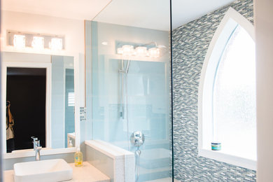 Example of a mid-sized transitional master blue tile and mosaic tile porcelain tile doorless shower design in Toronto with white cabinets, white walls, a vessel sink, quartz countertops and a one-piece toilet