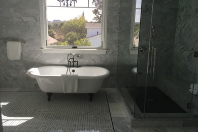 Foto di una stanza da bagno con vasca con piedi a zampa di leone, doccia ad angolo, piastrelle grigie, pareti grigie e porta doccia a battente