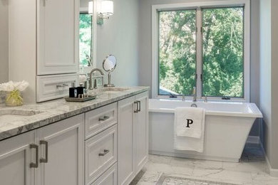 Mid-sized transitional master white tile and porcelain tile marble floor, multicolored floor and double-sink bathroom photo in Minneapolis with white cabinets, a one-piece toilet, gray walls, an undermount sink, quartzite countertops, a hinged shower door and gray countertops