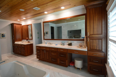 Bathroom - large transitional master marble floor and white floor bathroom idea in Orange County with raised-panel cabinets, dark wood cabinets, gray walls, an undermount sink, quartzite countertops, a hinged shower door and white countertops