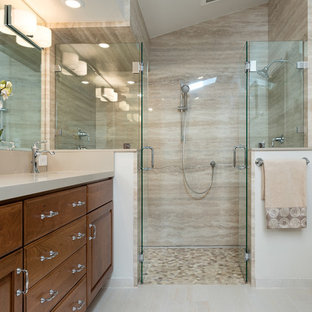 Klassisk inredning av ett mellanstort en-suite badrum, med möbel-liknande, skåp i mellenmörkt trä, ett fristående badkar, en dubbeldusch, en toalettstol med hel cisternkåpa, beige kakel, porslinskakel, beige väggar, klinkergolv i porslin, ett undermonterad handfat och granitbänkskiva