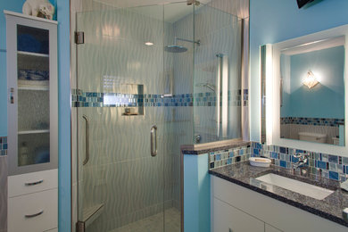 タンパにある高級な中くらいなモダンスタイルのおしゃれなバスルーム (浴槽なし) (フラットパネル扉のキャビネット、白いキャビネット、コーナー設置型シャワー、マルチカラーのタイル、モザイクタイル、青い壁、大理石の床、アンダーカウンター洗面器、御影石の洗面台、グレーの床、開き戸のシャワー、和式浴槽、分離型トイレ) の写真