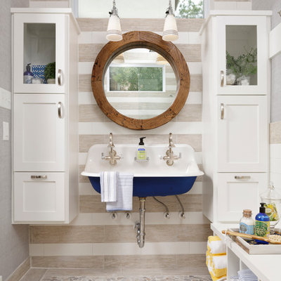 Inspiration for a mid-sized coastal 3/4 beige tile pebble tile floor and beige floor bathroom remodel in Houston with a wall-mount sink, shaker cabinets, white cabinets, gray walls and white countertops