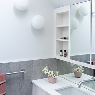 Photo of a contemporary bathroom in Melbourne with flat-panel cabinets, white cabinets, white walls, an undermount sink, white benchtops, a single vanity, a floating vanity and vaulted.