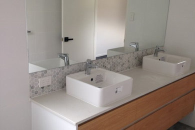 Mittelgroßes Badezimmer mit grauen Fliesen, Keramikfliesen, weißer Wandfarbe, Porzellan-Bodenfliesen, Aufsatzwaschbecken, Quarzwerkstein-Waschtisch und grauem Boden in Brisbane