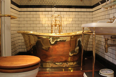 Exemple d'une salle de bain victorienne de taille moyenne pour enfant avec un lavabo de ferme, une baignoire indépendante, une douche à l'italienne, WC à poser, un mur multicolore et un sol en bois brun.