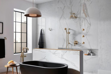 Diseño de cuarto de baño actual con bañera exenta, ducha abierta, baldosas y/o azulejos de mármol y ducha abierta