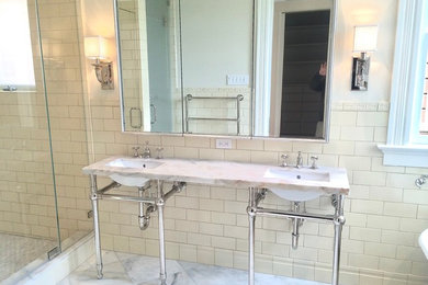 This is an example of a classic ensuite bathroom in San Francisco with freestanding cabinets, white cabinets, a claw-foot bath, a double shower, a wall mounted toilet, yellow tiles, ceramic tiles, marble flooring, a submerged sink, marble worktops, white floors and a hinged door.