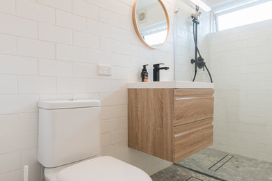 Exempel på ett litet modernt en-suite badrum, med möbel-liknande, skåp i ljust trä, en öppen dusch, en toalettstol med hel cisternkåpa, vit kakel, porslinskakel, vita väggar, klinkergolv i keramik, ett väggmonterat handfat, marmorbänkskiva, grått golv och med dusch som är öppen