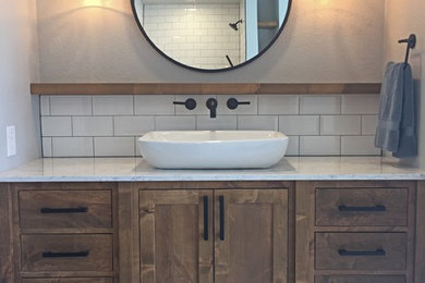 Design ideas for a medium sized farmhouse ensuite bathroom in Oklahoma City with shaker cabinets, medium wood cabinets, a freestanding bath, porcelain flooring, a vessel sink, engineered stone worktops and white floors.