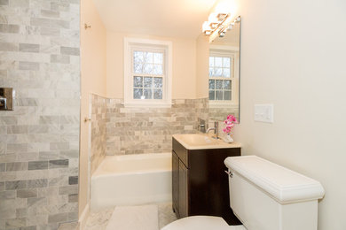 Bathroom - mid-sized transitional master gray tile and marble tile gray floor bathroom idea in Boston with flat-panel cabinets, dark wood cabinets, a one-piece toilet, white walls, an integrated sink and white countertops