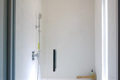 Mid-sized transitional master white tile and porcelain tile porcelain tile and gray floor alcove shower photo in Boston with flat-panel cabinets, medium tone wood cabinets, a two-piece toilet, beige walls, an undermount sink, quartz countertops, a hinged shower door and gray countertops