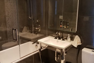 ニューヨークにある小さなコンテンポラリースタイルのおしゃれな浴室 (黒いタイル、開き戸のシャワー) の写真