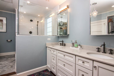 Cette photo montre une grande salle de bain principale chic avec un placard avec porte à panneau encastré, des portes de placard blanches, une douche d'angle, WC séparés, un carrelage blanc, un carrelage métro, un mur bleu, un sol en carrelage de porcelaine, un lavabo encastré, un plan de toilette en quartz, un sol gris, une cabine de douche à porte battante et un plan de toilette gris.