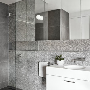 Photo of a mid-sized contemporary 3/4 bathroom in Melbourne with flat-panel cabinets, white cabinets, an open shower, gray tile, porcelain floors, an integrated sink, grey floor, an open shower, white benchtops, a single vanity and a floating vanity.