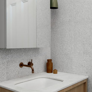 Modern bathroom in Melbourne with flat-panel cabinets, light wood cabinets, gray tile, an undermount sink, white benchtops and a single vanity.