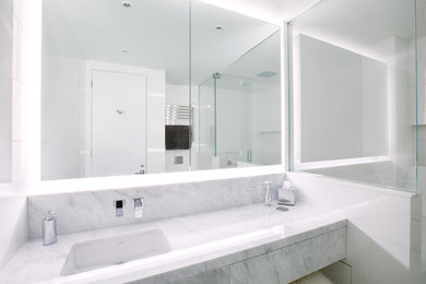 Example of a large minimalist master white tile and porcelain tile porcelain tile and white floor bathroom design in Other with white walls, an undermount sink, marble countertops, a hinged shower door and gray countertops