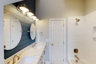 Example of a small transitional kids' white tile and porcelain tile porcelain tile and brown floor bathroom design in Raleigh with shaker cabinets, white cabinets, a two-piece toilet, gray walls, an undermount sink, quartz countertops and white countertops