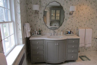Modelo de cuarto de baño principal tradicional de tamaño medio con armarios tipo mueble, puertas de armario grises, paredes multicolor, suelo de mármol, lavabo bajoencimera, encimera de mármol, suelo blanco y encimeras blancas