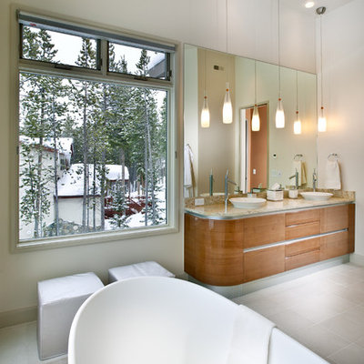 Inspiration for a large contemporary master beige tile and glass tile concrete floor and gray floor bathroom remodel in Atlanta with a vessel sink, flat-panel cabinets, medium tone wood cabinets, granite countertops, white walls and a one-piece toilet
