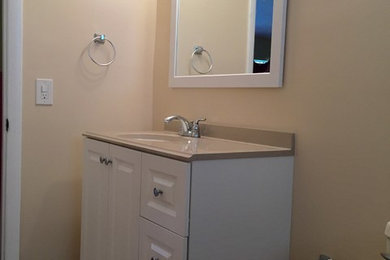 Example of a mid-sized trendy beige tile and ceramic tile ceramic tile drop-in bathtub design in Miami with white cabinets, a two-piece toilet, beige walls and an undermount sink