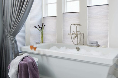 Trendy master marble floor and white floor freestanding bathtub photo in Phoenix with white walls