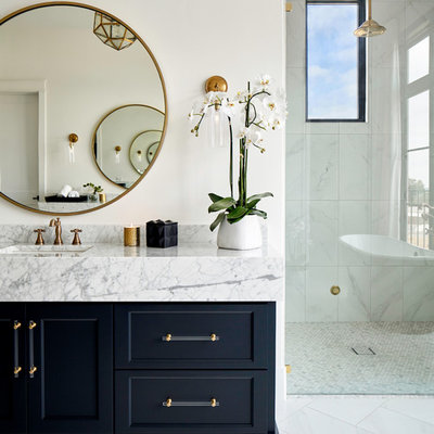 Bathroom - transitional master porcelain tile and white floor bathroom idea in Austin with recessed-panel cabinets, black cabinets, white walls, an undermount sink, quartz countertops, a hinged shower door and white countertops