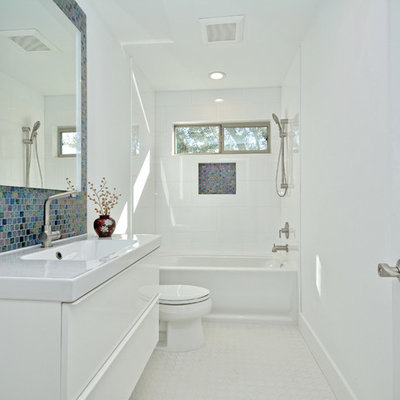 Example of a mid-sized eclectic master glass tile and multicolored tile bathroom design in Austin with flat-panel cabinets, white walls, medium tone wood cabinets, an undermount sink and quartz countertops