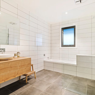 Contemporary wet room bathroom in Melbourne with flat-panel cabinets, medium wood cabinets, an alcove tub, white tile, a vessel sink, wood benchtops, grey floor, an open shower and brown benchtops.