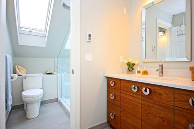 Idées déco pour une salle de bain contemporaine en bois brun de taille moyenne avec un placard à porte plane, un plan de toilette en quartz modifié, un carrelage gris, des carreaux de porcelaine, un mur beige et un sol en carrelage de porcelaine.