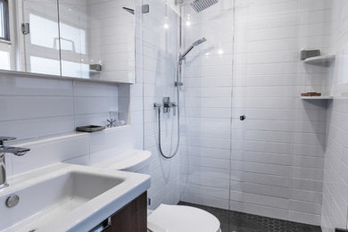 Wet room - small transitional master white tile and subway tile mosaic tile floor and black floor wet room idea in Vancouver with flat-panel cabinets, dark wood cabinets, a two-piece toilet, gray walls, an integrated sink, solid surface countertops, a hinged shower door and white countertops