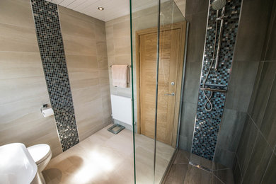 Photo of a medium sized contemporary bathroom in Other with a two-piece toilet, grey tiles, ceramic tiles, a console sink and a hinged door.