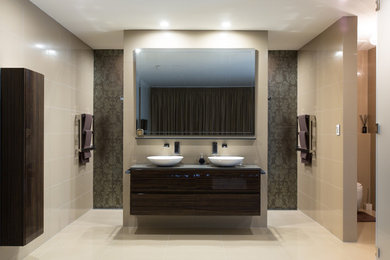 Modelo de cuarto de baño actual con baldosas y/o azulejos de cerámica y lavabo sobreencimera